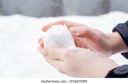 Kaukaskie dłonie formujące kulę śnieżną ze świeżego śniegu zimą w Europie. Ciesząc się zimną śnieżną pogodą po zmianie klimatu Bestii ze Wschodu.