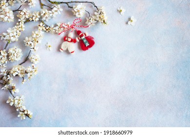 Ramas florecientes de ciruelas cereza y decoración símbolo rojo y blanco de la fiesta de la primavera del 1 de marzo sobre un fondo decorativo para texto, felicitaciones