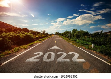 2022 escrito en carretera con flecha en medio de una carretera asfaltada vacía y un hermoso cielo azul. Concepto para la visión 2021-2022.