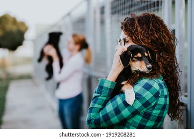 動物保護施設で美しい犬を養子にする 2 人の若い成人女性。