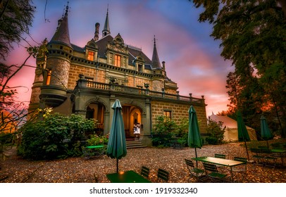Mysterious mansion at sunset in Halloween. Manor with cafe tables at sunset. Sunset manor. Sunset mansion house