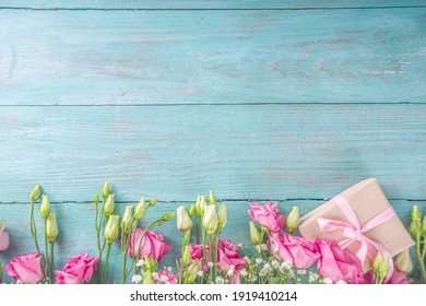 Schöne Frühlingsblumen auf hellblauem Holzhintergrund. Festliche Blumenkomposition mit Kraftpapier-Geschenkboxen. Valentinstag, Frauentag, Muttertagsgrußkarte. Ansicht von oben flach liegend