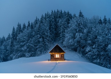 Fantástico paisaje invernal con una cabaña de madera brillante en un bosque nevado. Acogedora casa en las montañas de los Cárpatos. concepto de vacaciones de navidad