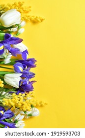 heller Frühlingsstrauß auf gelbem Hintergrund. weiße Tulpen, Schwertlilien, sanfte Mimosen. Frühlingsstimmung. Frühlingskarte zum Muttertag oder Frauentag, Valentinstag. Leerzeichen kopieren. Selektiver Fokus