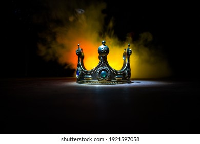 low key image of beautiful crown over wooden table. vintage filtered. fantasy medieval period. Selective focus. Colorful backlight