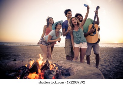 Sekelompok teman bersenang-senang di pantai membuat bonefire