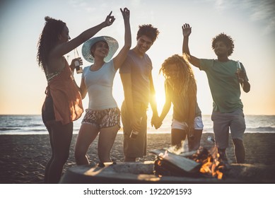 Sekelompok teman bersenang-senang di pantai membuat bonefire