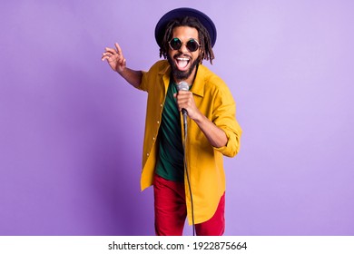 Retrato de una persona loca y divertida de piel oscura con la boca abierta cantar diviértete de buen humor aislado en un fondo de color púrpura
