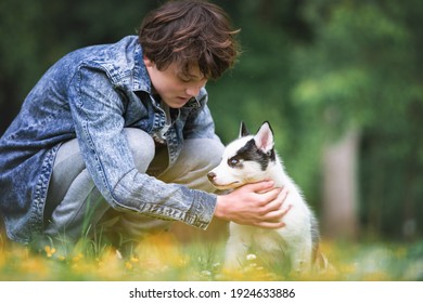 Tiener met witte hondenras Siberische husky op lente achtertuin. Honden en huisdieren fotografie