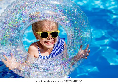 ライフラインを保持しているプールでサングラスで金髪のかわいい女の子が笑います。高品質の写真