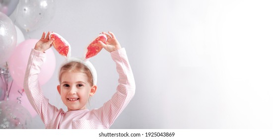 Nettes lustiges kleines Mädchen mit Hasenohren am Ostertag. Glückliches Kind Nahaufnahme auf grauem Hintergrund mit rosa Luftballons bei Geburtstagsfeier. Osterferienkonzept. Alles Gute zum Geburtstag Banner. Platz für Text
