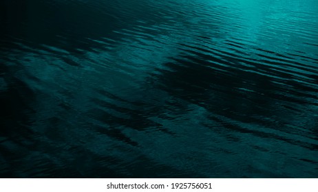 Dark blue green abstract background. Reflection of light on a smooth surface of water with small waves. Tidewater green background with copy space for design. Web banner.