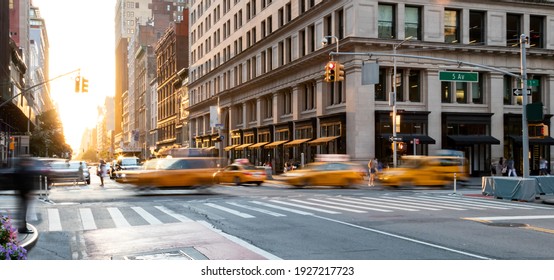 Yellow taxis driving through the busy intersection of 5th Avenue and 23rd Street in Manhattan, New York City USA