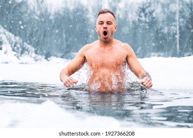 Hombre saltando en agua fría en invierno