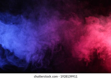 Artificial smoke in red-blue light on black background in darkness