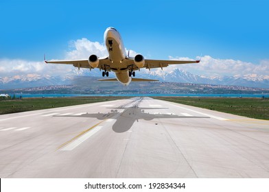 Wit passagiersvliegtuig vliegt omhoog over startbaan vanaf luchthaven