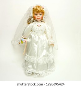 una muñeca vintage con un hermoso vestido de novia en el fondo blanco