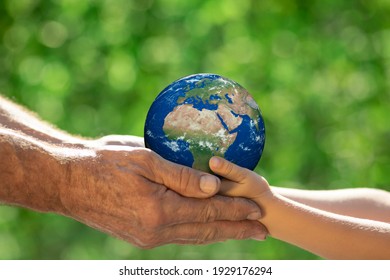 緑の背景をぼかした写真に対して手で 3 D の惑星を保持している家族。地球の日の春休みのコンセプト。NASA から提供されたこの画像の要素