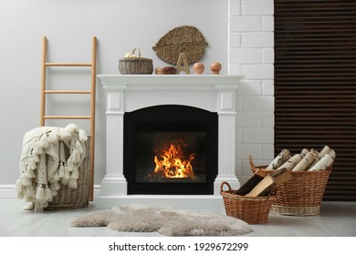 Weidenkörbe mit Brennholz und weißem Kamin im gemütlichen Wohnzimmer