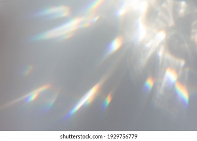 Verschwommener Regenbogen-Lichtbrechungs-Textur-Overlay-Effekt für Fotos und Mockups. Diagonales holografisches Aufflackern des organischen Tropfens auf einer weißen Wand. Schatten für natürliche Lichteffekte