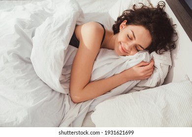 Vrouw slapen. Hoge hoekmening van mooie jonge vrouw die in bed ligt en de ogen gesloten houdt terwijl ze bedekt is met een deken. Stock foto