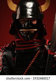 Seorang pemuda Eropa dengan kostum samurai ronin tradisional Jepang dengan pedang katana di latar belakang gelap dan di jalan. Cosplay dan Karnaval