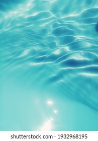 Resumen de desenfoque de primer plano de la superficie del agua azul. Resumen de la superficie del agua azul reflejada con la luz del sol como fondo. Vista superior del agua azul. El agua salpicada se usa para el diseño gráfico
