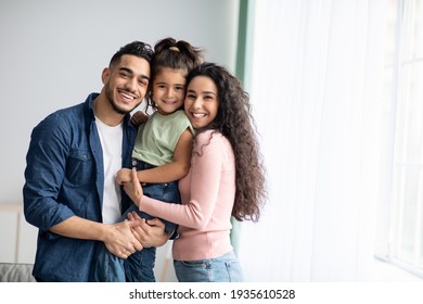 家で小さな娘とポーズをとる幸せなアラビア語の両親のポートレイフ