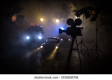 Aksiyon filmi konsepti. Sisli koyu tonlu arka planda polis arabaları ve minyatür film seti. Gece bir arabayı kovalayan polis arabası. Suç mahalli kaza. Seçici odak