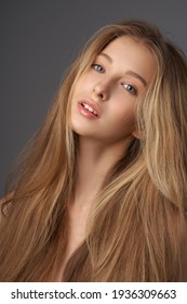 Chân dung tự nhiên của cô gái tuổi teen trẻ đẹp với mái tóc dài thẳng. Studio chụp người mẫu nữ trên nền xám. Cô gái xinh đẹp