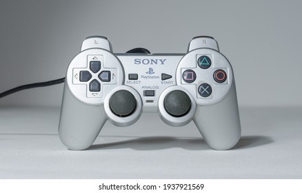 london, uk 05.05.2020 A wired official play station 2, silver rare dual shock 2 controller on a white studio backdrop. collectable rare home arcade video gaming. joystick and wireless remote tech