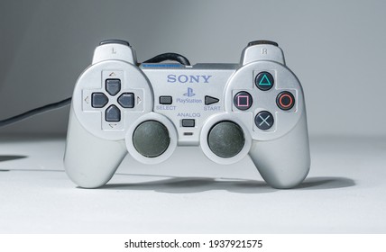 london, uk 05.05.2020 A wired official play station 2, silver rare dual shock 2 controller on a white studio backdrop. collectable rare home arcade video gaming. joystick and wireless remote tech