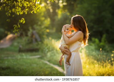 Young beautiful mother plays with her child outdoor.