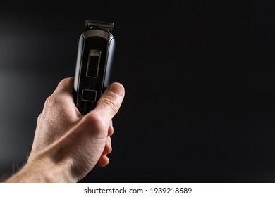 Wireless razer in man's hand on black background with copy space.
