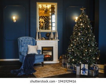 Silla azul, chimenea, árbol de Navidad con regalos.