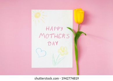 "Happy mother's day" greeting card for Mom drawn by kid on Mother's Day with yellow tulip on pastel pink background. Congratulations and greetings for Mom on special day. Minimalism.