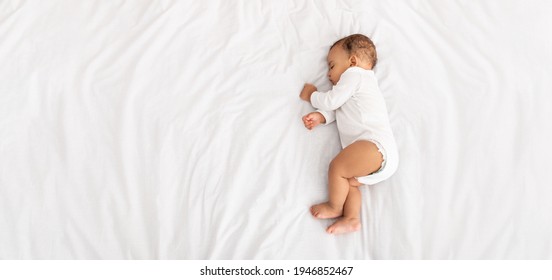 屋内のベッドで横になっている側で寝ている男の子の高角度のビュー。家のコンセプトで昼間の睡眠中に昼寝を休んでいるかわいい幼児の子供。トップ ビュー ショット。コピー スペースのパノラマ