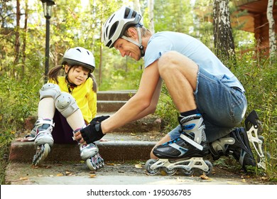 ヘルメットをかぶったスポーツのお父さんと娘のポートレート。スケートで彼の小さな娘とお父さん