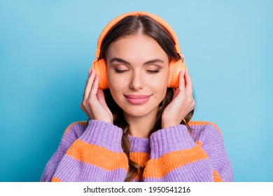 Photo of adorable girl closed eyes arms on headphones listen to favorite single isolated on blue color background