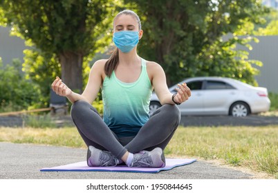 Kvinde i en beskyttende maske praktiserer meditation i naturen, kørte ud af byen i bil. Yoga lotusstilling - åndedrætsøvelser, aktiv sund livsstil. Social afstand.