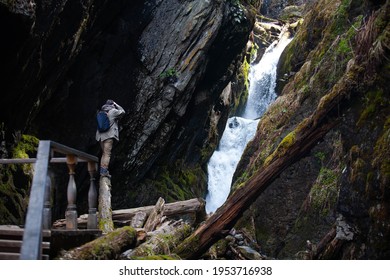 Photographer risking his life shoots a waterfall, Siberia, Altai Mountains, Lake Teletskoye
