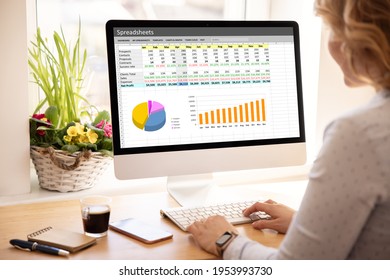 Woman working with spreadsheets on desktop computer