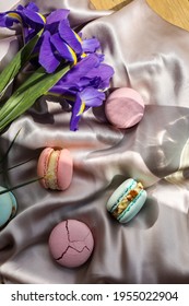 colorful delicious homemade traditional french macarons - elegant french dessert. Natural fruit and berry flavors, creamy stuffing and blue iris flowers on cloth for valentines mother day easter.