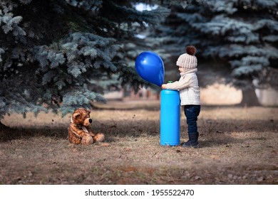 Ein kleiner Junge bläst einen Ballon mit Helium auf. Baby und sein Freundbär im Park. Winnie Puuh. Frühlingsspaziergang eines Kindes mit einem Spielzeug. Kindheit. Basierend auf einem Märchen. Heliumtank