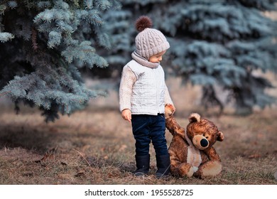 Baby und sein Freundbär im Park. Winnie Puuh. Frühlingsspaziergang eines Kindes mit einem Spielzeug. Kindheit. Basierend auf einem Märchen.