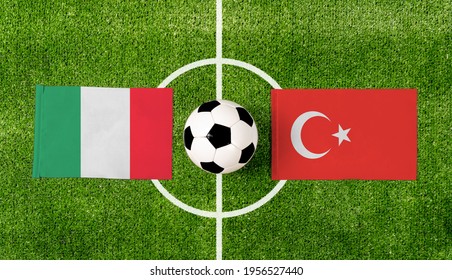 Bovenaanzicht bal met Italië vs. Turkije vlaggen match op groen voetbalveld.