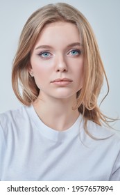 Portrait of a beautiful young woman with blonde hair and natural make-up. Studio shot on a white background. Beauty industry.
