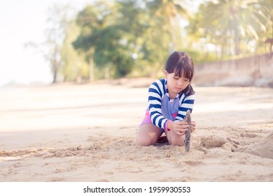 7 歳のアジアの女の子は、海のビーチで彫刻の白い砂を再生します。休暇とリラックスします。夏休みと子供の発達のビーチで遊び心のあるアクティブな子供。タイの砂のビーチでアジアの子供の女の子が遊びます。
