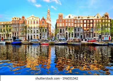 Canal houses of Amsterdam at dusk with vibrant reflections, Netherlands