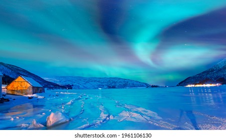 Nordlicht (Aurora borealis) am Himmel über Tromsø, Norwegen - Aurora Reflexion auf dem Meer im Hintergrund Norwegischer Fjord - Wintersaison.